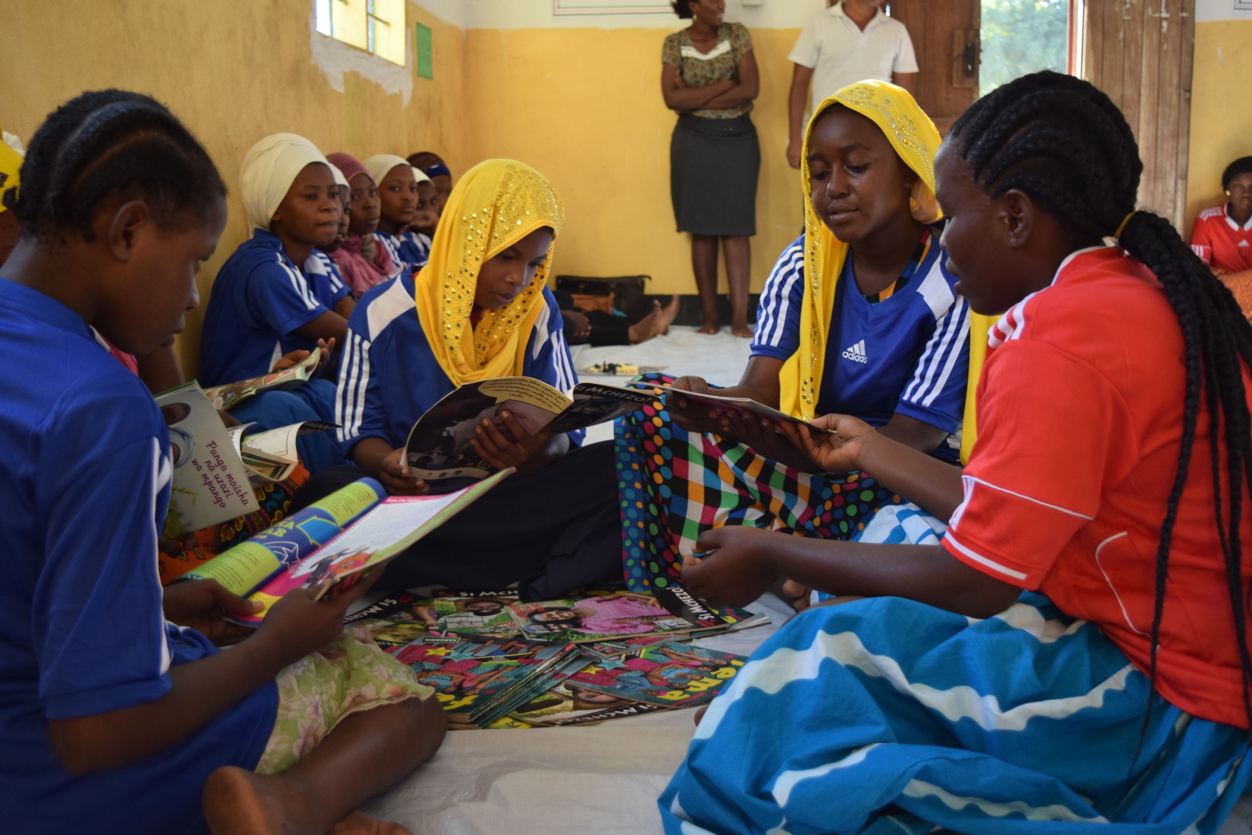 Girls in a youth club in Tanzania read books on social issues as part of the ELA Program. © 2016 BRAC Maendeleo Tanzania/BRAC