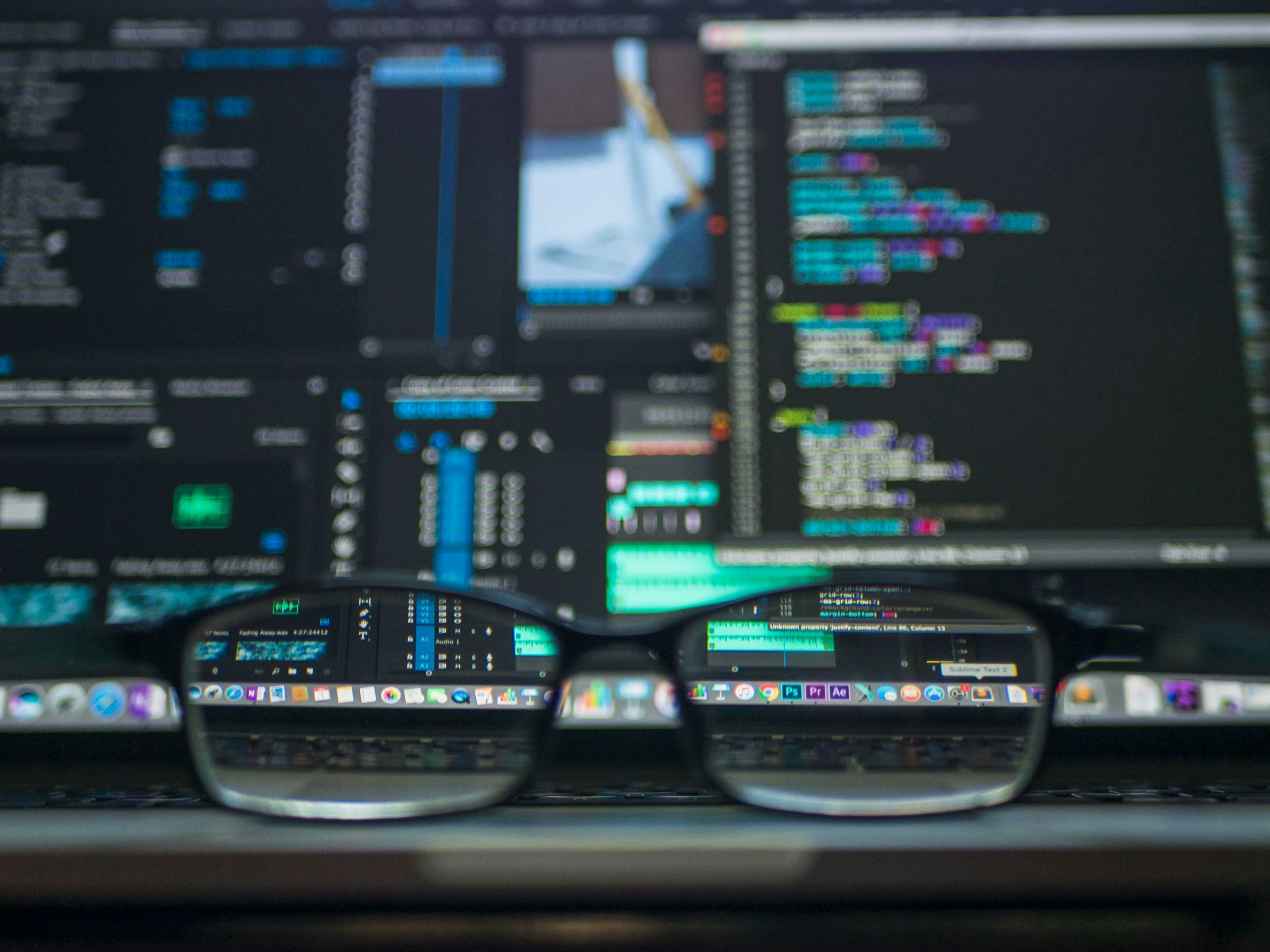 Image of glasses perched in front of a laptop screen showing data and code. Image by Kevin Ku via Unsplash.