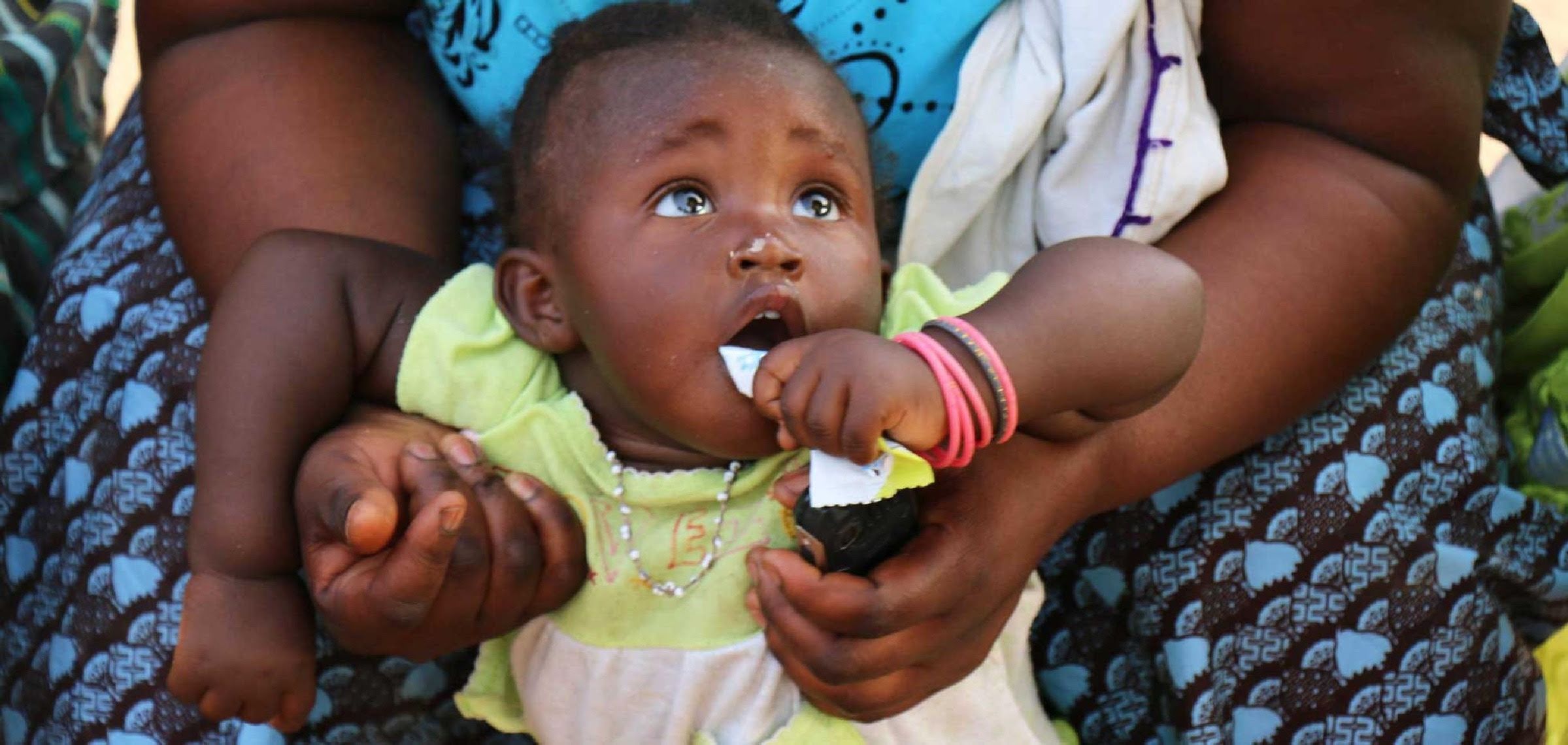 A child eats a lipid-based nutrient supplement product from the Enov range in Burkina Faso. © Nutriset