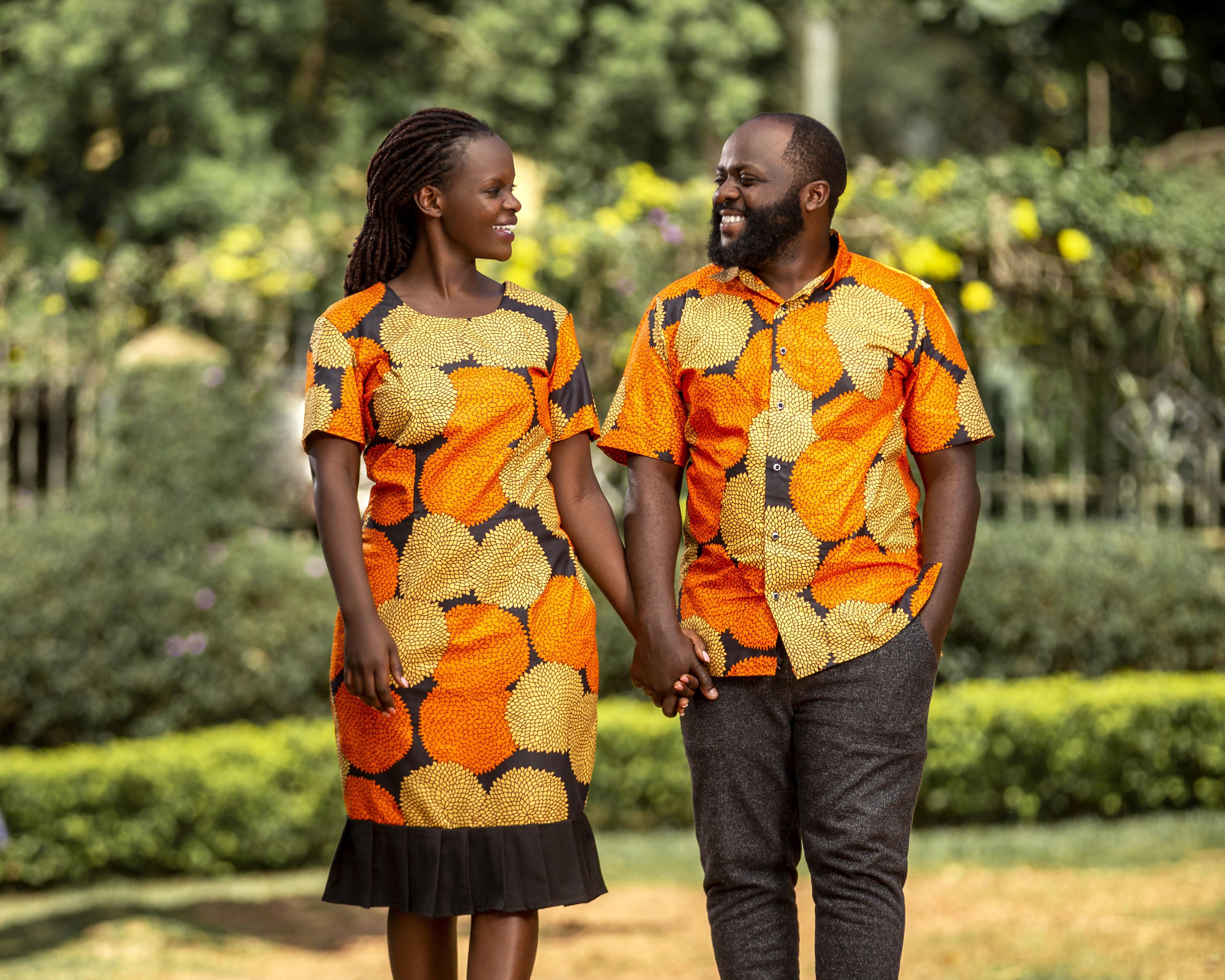 A man and a woman holding hands and smiling while walking together outdoors